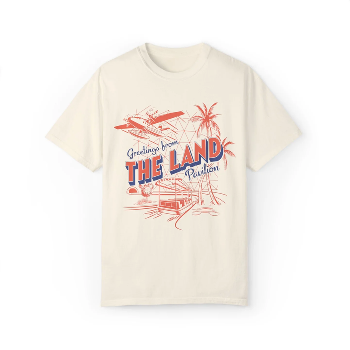 Living with the Land Pavilion Tee in Ivory, front flat lay with Greetings from The Land Pavilion postcard design
