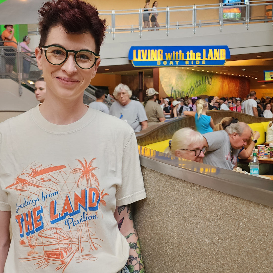 Kylie in the Land Pavilion Tee in Ivory inside The Land below the Living with the Land boat ride sign