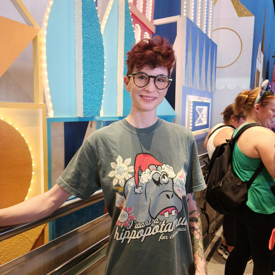 Kylie wearing the I Want a Hippopotamus for Christmas Shirt in Blue Spruce inside it's a small world