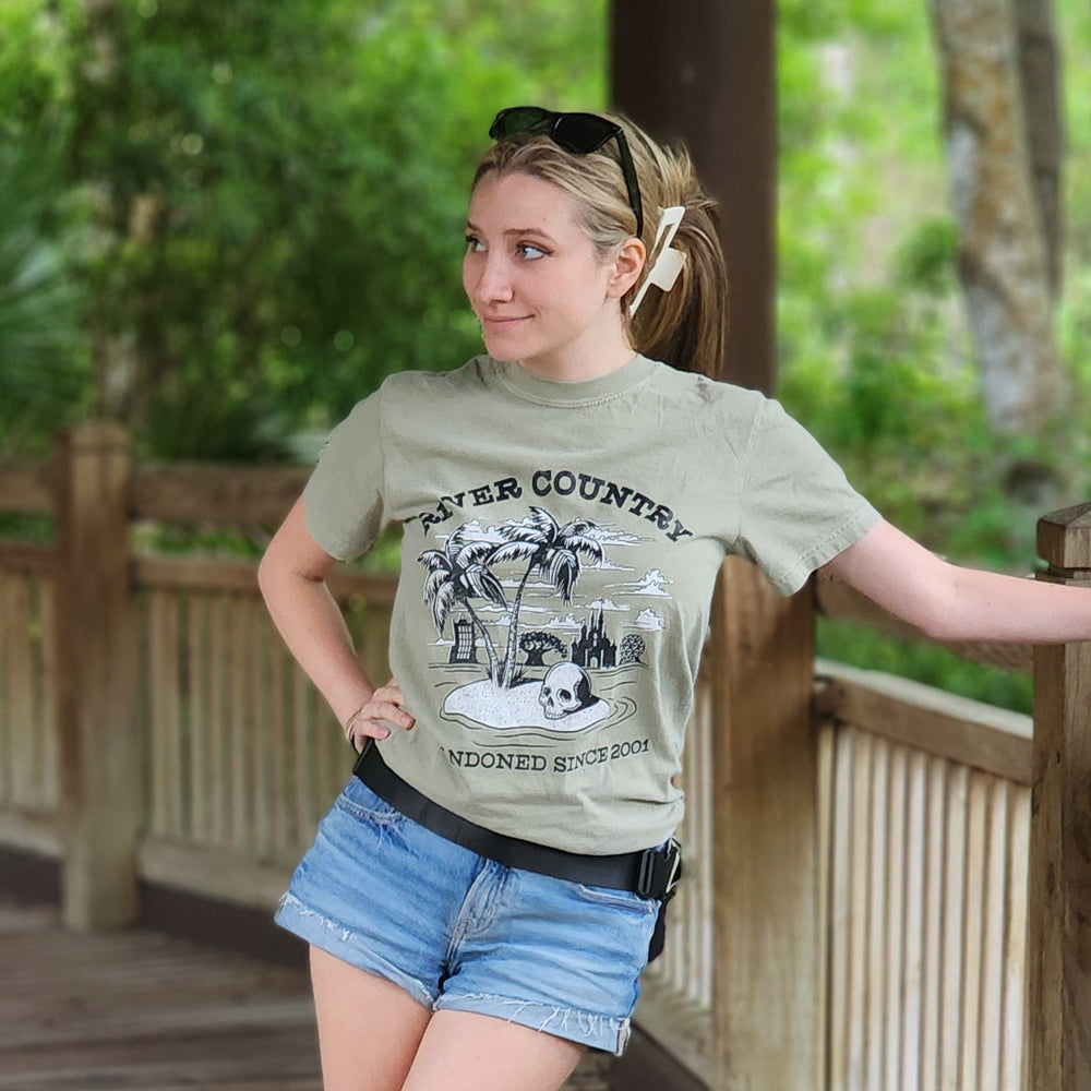 Person standing on a wooden deck with greenery in the background wearing the River Country Disney Shirt