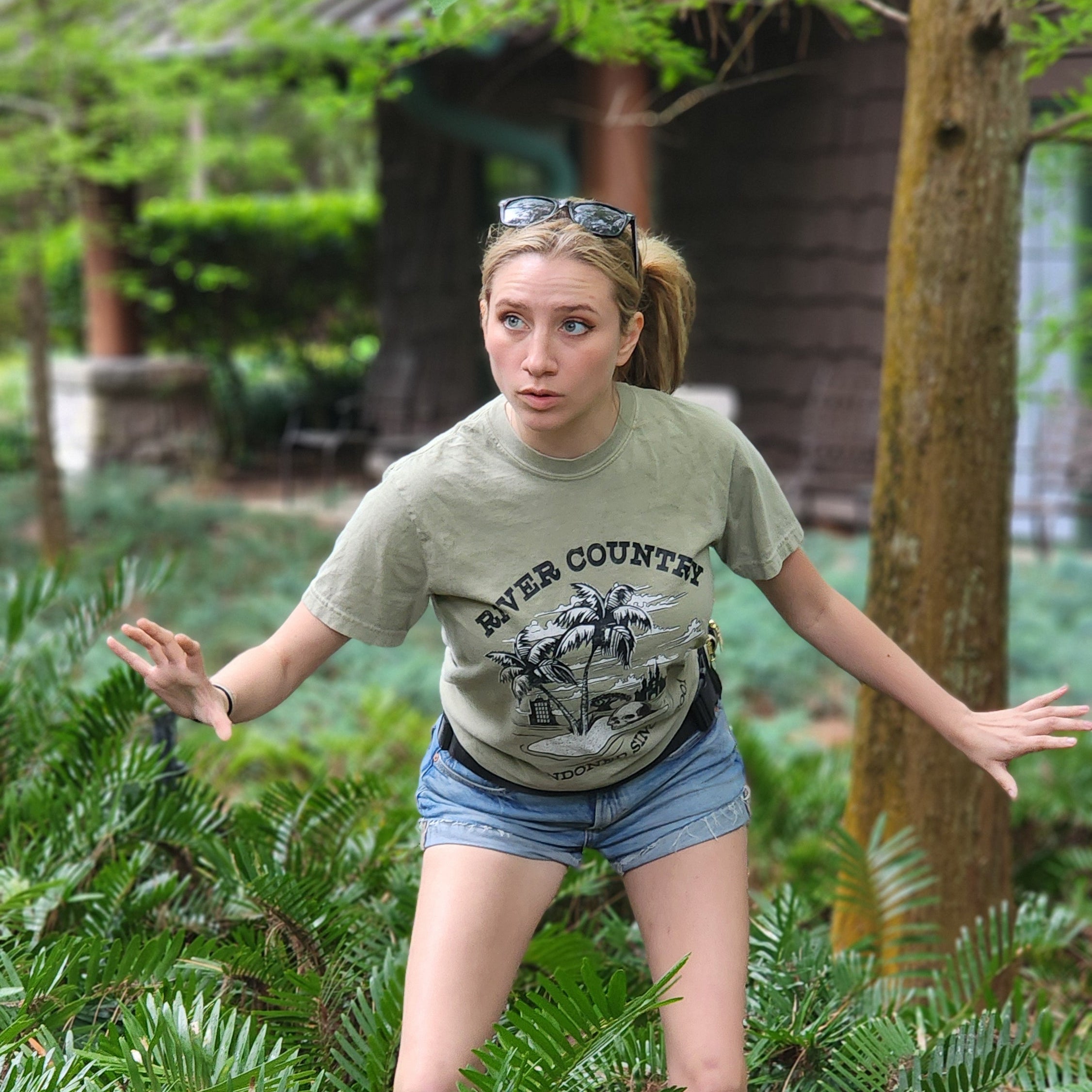 Person standing on a wooden deck with greenery in the background wearing the River Country Disney Shirt