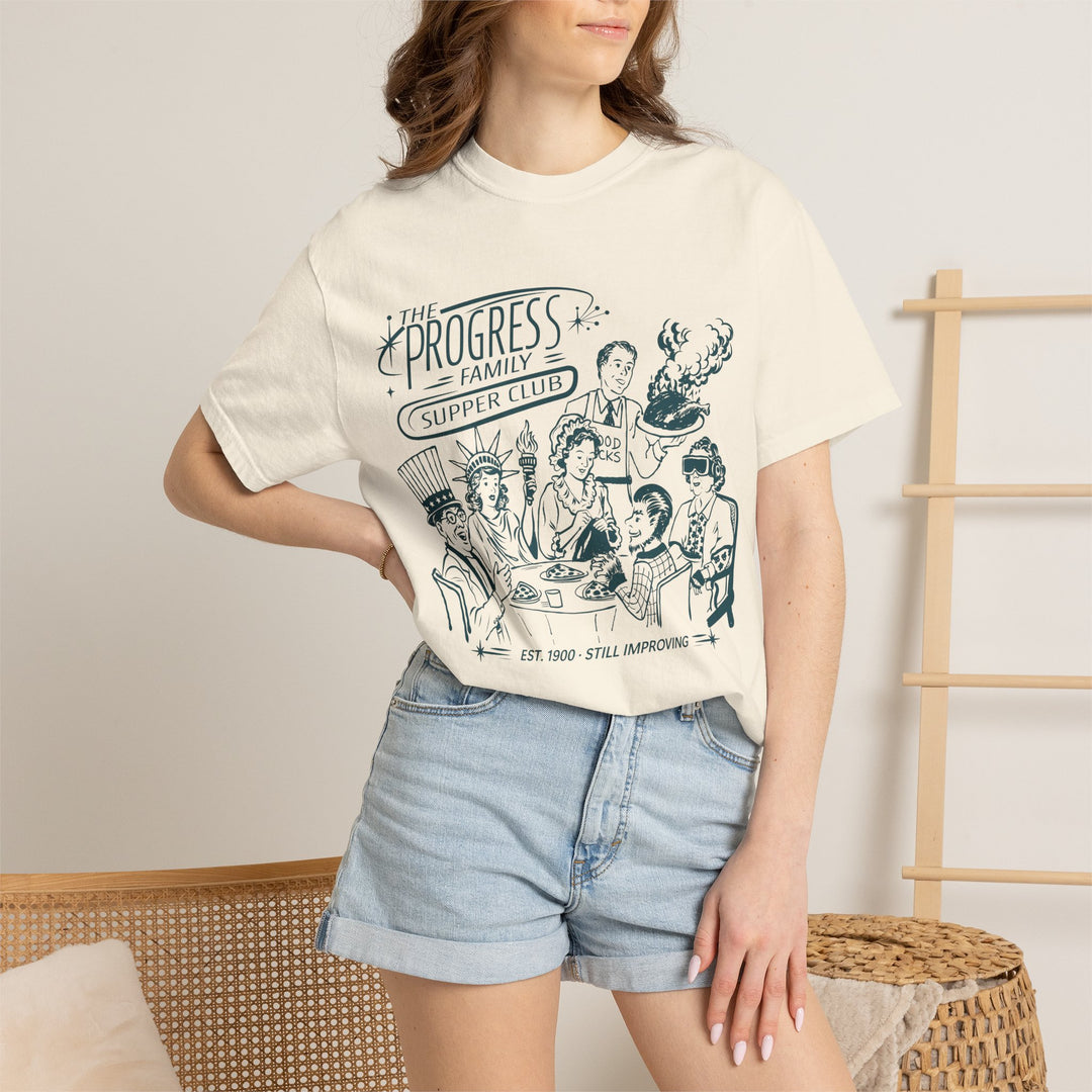 Carousel of Progress Supper Club Tee in Ivory worn by a woman in denim shorts, front view of the family dinner print