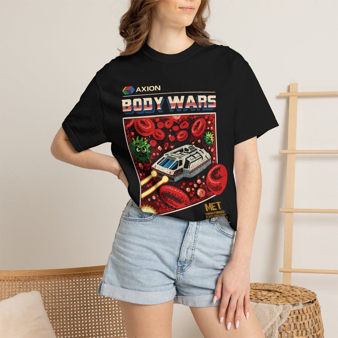 Body Wars Tee in Black worn by a woman in denim shorts, hand on hip, in a room with a wooden ladder shelf