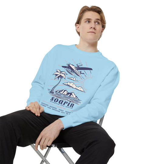 Soarin' Sweatshirt in Chambray worn by a man seated on a folding chair, showing the EPCOT Soarin design