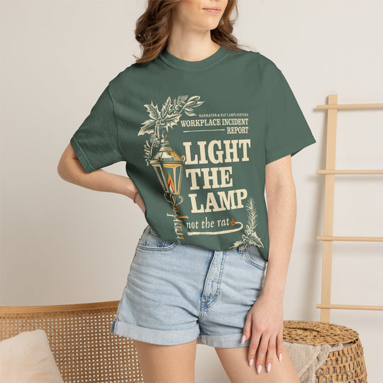 Light the Lamp, Not the Rat Christmas Shirt in Blue Spruce worn by a woman in denim shorts with a hand on her hip