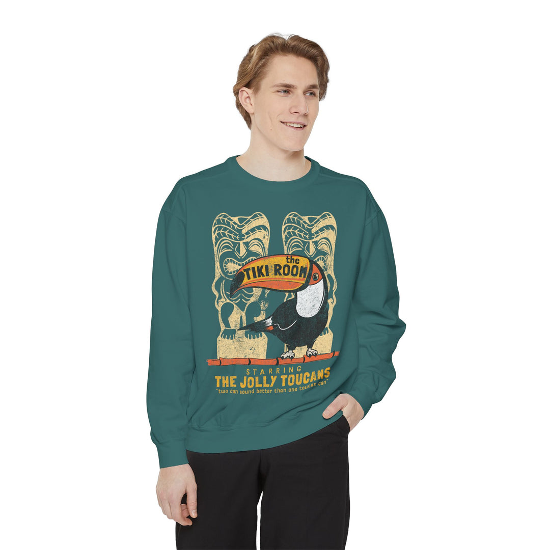 Tiki Room Sweatshirt in Blue Spruce worn by a smiling young man in black pants, front view on a white background