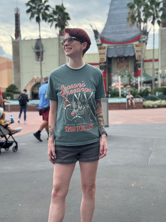 Kylie wearing the Season's Greetings from Echo Lake Shirt in Blue Spruce near the Chinese Theatre