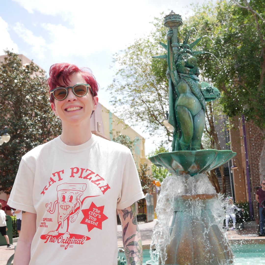 Kylie, Owner of Quirky Mouse, standing in the Rat Pizza tee in front of MuppetVision 3d
