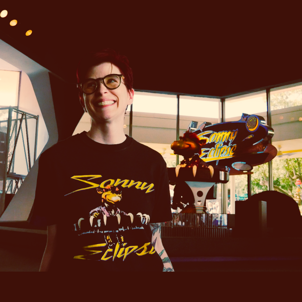 Kylie in the Sonny Eclipse Tee standing in front of the Sonny Eclipse animatronic at Cosmic Ray's
